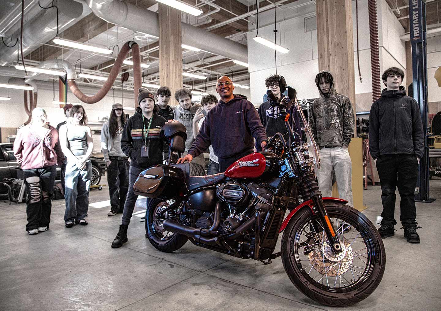 High School kids and teach stand behind custom Harley Davidson