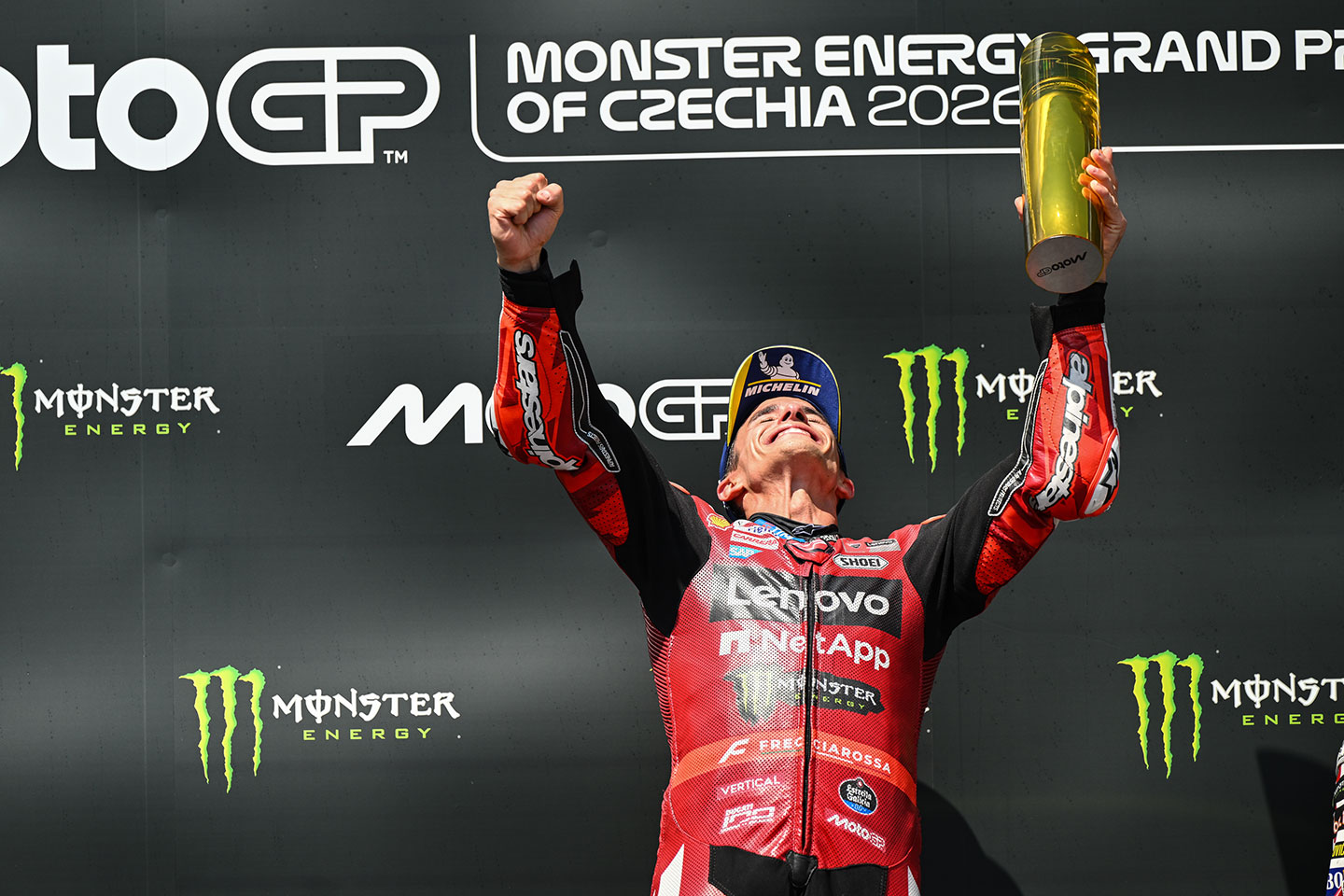 Marc Marquez raises hands on podium at MotoGP race